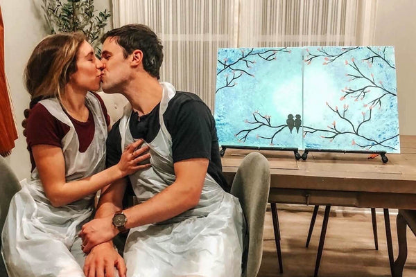 Couple enjoying a paint night at home. Painting together with a Painting to Gogh date night kit.