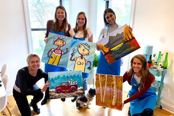 Paint Party at Home with multiple people holding their finished canvases 
